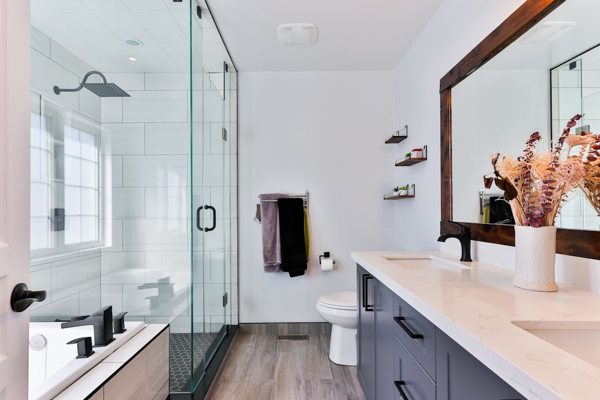 Chrome showerhead and shower arm against tiled bathroom wall